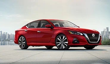 2023 Nissan Altima in red with city in background illustrating last year's 2022 model in Reiselman Nissan in Kansas City MO